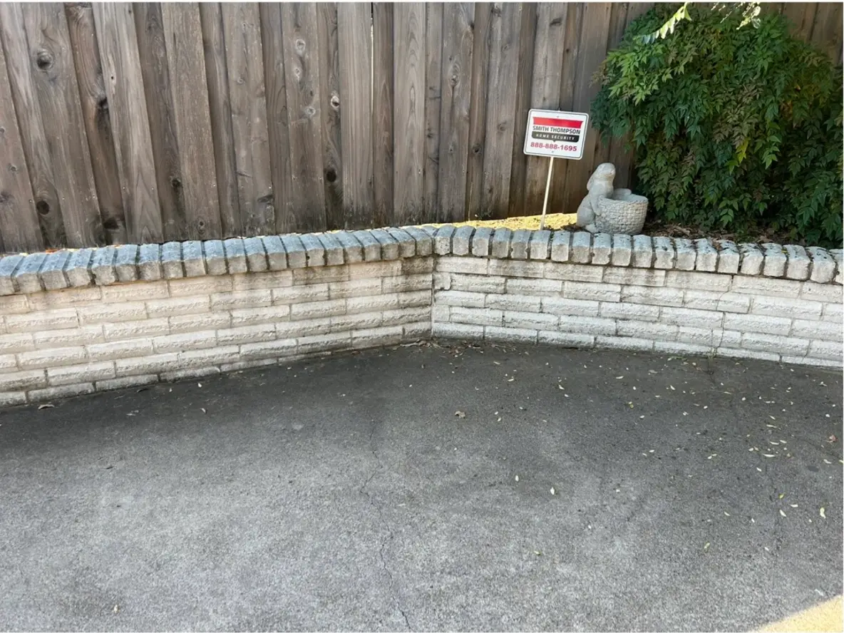 Brick wall and patio before pressure washing