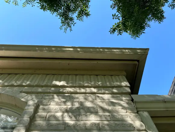 Clean gutter and fascia on a brick home after exterior washing