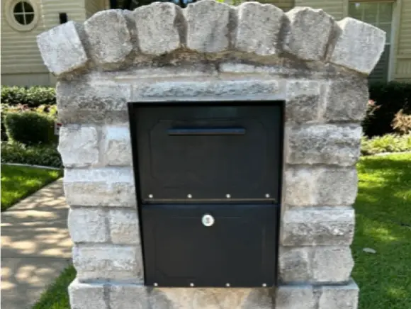 Brick mailbox before cleaning, stained with mildew and dirt